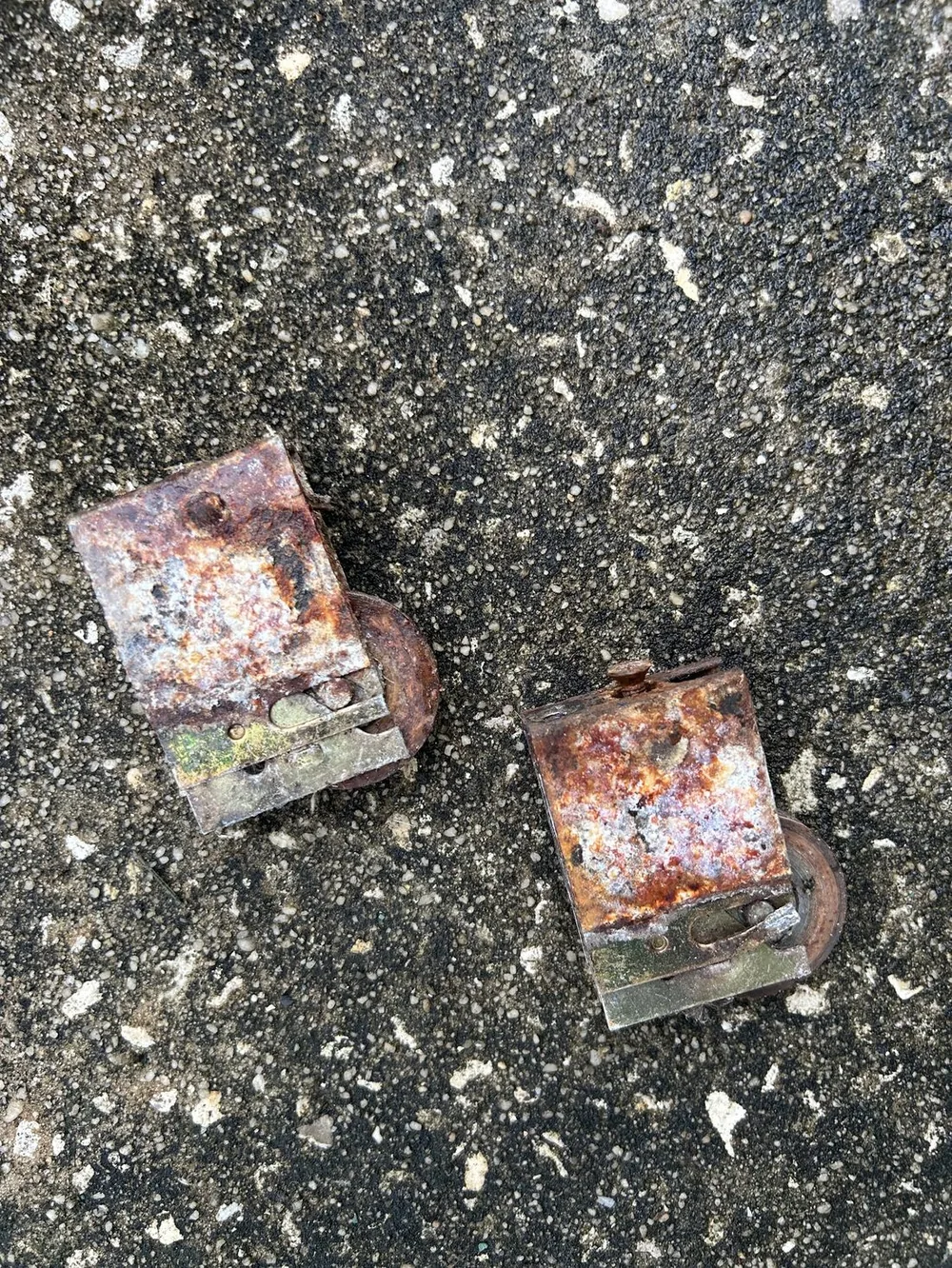 Rusted, corroded sliding door rollers removed from a door